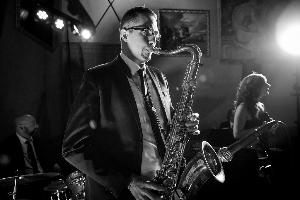 Black and white photo of a saxophonist with the vocalist behind him at a wedding in Italy
