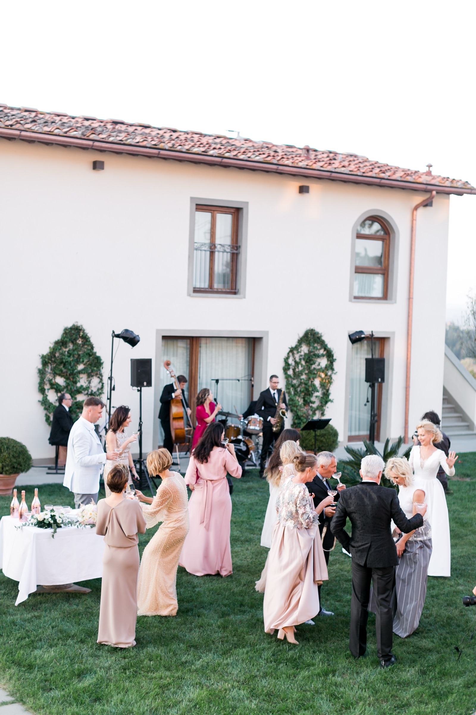 Italian jazz band playing on the lawn of a Tuscan villa while wedding guests drink and dance