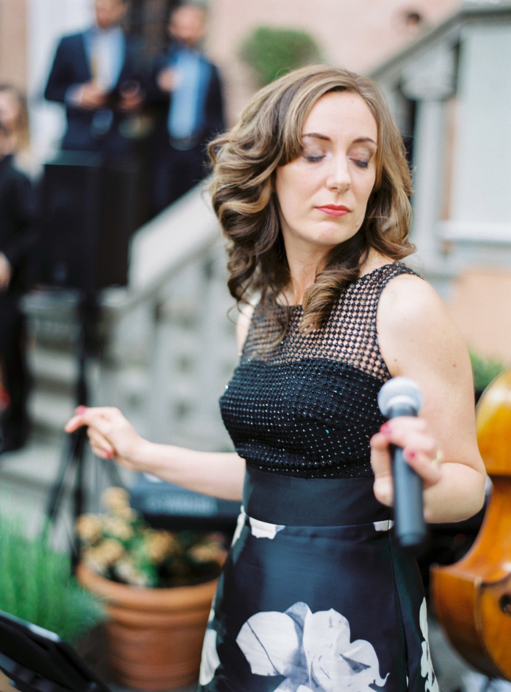 Vocalist in a black and white floral gown singing with eyes closed at a luxury wedding in Florence