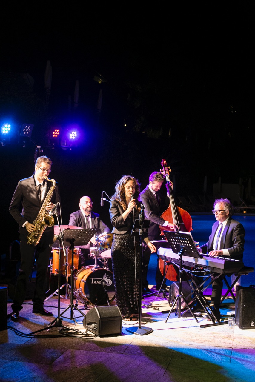 Italian jazz band on a night stage by the pool at a wedding in Portofino, with sax, drums, vocalist, bass and keyboard
